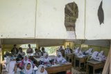 Siswa mengikuti kegiatan belajar mengajar di ruang kelas yang rusak dan bolong di MTS Nurussalam, Kutawaringin, Kabupaten Bandung, Jawa Barat, Senin (15/1). Ruang kelas MTS Nurussalam tersebut rusak dan bolong sejak beberapa tahun lalu dan masih digunakan untuk kegiatan belajar dan mengajar sekitar 28 murid kelas VIII yang berasal dari kawasan Kabupaten Bandung dan Kabupaten Bandung Barat. ANTARA JABAR/Novrian Arbi