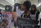 Mahasiswa jurusan teknik komputer Politeknik Elektronika Negeri Surabaya (PENS) Alviansyah Arman (kiri), Alfandino Rasyid (tengah) dan Khairani Arlinda menyiapkan alat penghasil air minum otomatis (Apatis) yang dapat mengubah udara menjadi air saat Software Expo 2018 di kampus PENS, Surabaya, Jawa Timur, Selasa (16/1). Software Expo 2018 tersebut merupakan wadah untuk mengapresiasi sekaligus memotivasi mahasiswa dalam menghasilkan produk perangkat lunak terbaik. Antara Jatim/Moch Asim/zk/18 