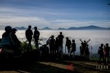 Wisatawan menikmati cahaya matahari pertama tahun 2018 di Bukit Caringin Tilu, Kabupaten Bandung, Jawa Barat, Senin (1/1). Bukit Caringing Tilu atau dikenal dengan sebutan Cartil menjadi salah satu kawasan favorit warga dan wisatawan untuk menikmati cahaya terbit matahari di Bandung. ANTARA JABAR/Novrian Arbi