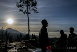 Wisatawan menikmati cahaya matahari pertama tahun 2018 di Bukit Caringin Tilu, Kabupaten Bandung, Jawa Barat, Senin (1/1). Bukit Caringing Tilu atau dikenal dengan sebutan Cartil menjadi salah satu kawasan favorit warga dan wisatawan untuk menikmati cahaya terbit matahari di Bandung. ANTARA JABAR/Novrian Arbi