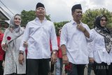 Bakal calon Gubernur Jawa Barat TB Hasanuddin (kiri) dan bakal calon Wakil Gubernur Jawa Barat Anton Charliyan (kedua kiri) berjalan didampingi istri saat mendaftar pasangan calon Pemilu Gubernur Jabar 2018 di Kantor Komisi Pemilihan Umum (KPU) Jawa Barat, Bandung, Jawa Barat, Rabu (10/1). Pasangan TB Hasanuddin dan Anton Charliyan diusung oleh Partai PDIP untuk Pemilu Gubernur Jawa Barat 2018. ANTARA JABAR/Novrian Arbi