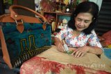 Perajin menyelesaikan pembuatan tas berbahan dasar daur ulang bekas bungkus semen disalah satu industri rumahan Surabaya, Jawa Timur, Rabu (10/1). Kejainan tas tersebut sebulan mampu meraup keuntungan hingga Rp5 juta dijual dengan harga Rp15 ribu hingga Rp500 ribu tergantung dari ukuran, bentuk dan jenis. Antara jatim/M Risyal Hidayat/zk/18