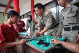 Petugas Satpol PP memeriksa ponsel milik sejumlah pelajar yang diamankan lantaran kedapatan bolos sekolah di Kantor Satpol PP Kota Blitar, Jawa Timur, Kamis (18/1). Penindakan terhadap sejumlah pelajar bolos tersebut dilakukan sebagai salah satu upaya untuk menekan angka kenakalan pelajar yang dikhawatirkan akan berlanjut pada penyalahgunaan narkoba. Antara Jatim/Irfan Anshori/zk/18 