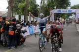 Pebalap sepeda asal Yunani Charalampos Kastrantas (kiri) dari tim Java Partizan Pro Cycling Team melakukan selebrasi setelah melewati garis finis di Taman Blambangan, Banyuwangi, Jawa Timur, Sabtu (27/1). Etape ke-3 Tour de Indonesia tersebut, start dari Probolinggo melalui Lumajang, Jember dan finish di Banyuwangi dengan jarak 200 kilometer. Antara Jatim/Budi Candra Setya/zk/18.