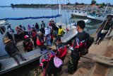 Penumpang naik ke atas perahu bermotor di Pelabuhan Tanjung, Sumenep, Jawa Timur, Minggu (7/1). Perahu menjadi satu-satunya  transportasi untuk menghubungkan warga ke sejumlah pulau dengan tarif Rp10.000-Rp50.000 sekali jalan. Antara Jatim/Saiful Bahri/zk/17.
