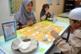 Pengunjung menikmati makanan sambil bermain matematika di Cafe Bayar Seikhlasnya (BASI), jalan raya Laladon, Ciomas, Kabupaten Bogor, Jawa Barat, Sabtu (27/1). Cafe yang menawarkan makanan dan minuman dengan metode pembayaran seiklasnya tersebut juga mengenalkan dan mengajak masyarakat untuk belajar matematika melalui permainan yang menarik dan menyenangkan.      (ANTARA FOTO/Arif Firmansyah/18).