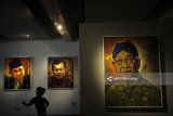 Pengunjung mengamati karya lukis bertema Tokoh Bangsa karya Jupri Abdullah, di Orasis Art Gallery, Surabaya, Jawa Timur, Selasa (16/1). Sebanyak 25 karya lukis sejumlah potret tokoh nasional tersebut dipamerkan hingga 21 Januari 2018. Antara Jatim/Zabru Karuru/zk/18 