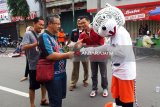 Komisioner KPU Kota Kediri dengan sejumlah tim KPU lainnya memberikan brosur tentang Pilkada Kota Kediri pada warga di acara 