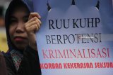 Massa yang tergabung dalam Jaringan Kerja Penanganan Kasus Kekerasan Terhadap Perempuan dan Anak (JANGKAR PKtPA) membentangkan poster saat menggelar aksi damai tolak Rancangan Undang-undang (RUU) Kitab Undang-undang Hukum Pidana (KUHP), di Surabaya, Jawa Timur, Kamis (15/2). Massa menuntut agar sejumlah pasal dalam RUU KHUP tersebut dihapus karena dianggap berpotensi mengkriminalisasi perempuan, anak dan kelompok rentan. Antara Jatim/Moch Asim/zk/18