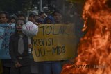 Mahasiswa yang tergabung dalam Pergerakan Mahasiswa Islam Indonesia (PMII) membakar ban saat melakukan aksi di depan Gedung DPRD Jabar, Bandung, Jawa Barat, Rabu (28/2). Mereka menolak pasal-pasal yang bertentangan dengan nilai-nilai demokrasi atas fungsi dan wewenang DPR yang diatur dalam revisi UU MD3. ANTARA JABAR/Raisan Al Farisi/agr/18.