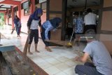 Sejumlah siswa membersihkan ruang kelas yang terkena banjir di SMPN 1 Bungatan, Situbondo, Jawa Timur, Rabu (14/). Kegiatan belajar mengajarÂ di sekolah tersebut terganggu akibat banjir menggenangi delapan ruang kelas dengan ketinggian air mencapai 25 Cm, merobohkan pagar sekolah sepanjang 100 meter. Antara Jatim/Seno/18.