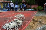 Sejumlah siswa dan guru membersihkan peralatan belajar yang terkena banjir di SMPN 1 Bungatan, Situbondo, Jawa Timur, Rabu (14/). Kegiatan belajar mengajarÂ di sekolah tersebut terganggu akibat banjir menggenangi delapan ruang kelas dengan ketinggian air mencapai 25 Cm, merobohkan pagar sekolah sepanjang 100 meter.Antara Jatim/Seno/zk/18.