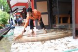 Seorang guru dan siswa membersihkan ruang kelas yang terkena banjir di SMPN 1 Bungatan, Situbondo, Jawa Timur, Rabu (14/). Kegiatan belajar mengajarÂ di sekolah tersebut terganggu akibat banjir menggenangi delapan ruang kelas dengan ketinggian air mencapai 25 Cm, merobohkan pagar sekolah sepanjang 100 meter. Antara Jatim/Seno/zk/18