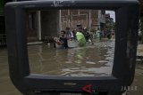 Warga menggunakan perahu untuk melintasi genangan banjir di Kampung Bojongasih, Dayeuhkolot, Kabupaten Bandung, Jawa Barat, Senin (26/2). Banjir akibat luapan sungai citarum dan intensitas curah hujan yang tinggi tersebut telah merendam sedikitnya 9000 rumah dengan 24.000 jiwa terdampak banjir dari 8 kecamatan di Kabupaten Bandung. ANTARA JABAR/Novrian Arbi/agr/18