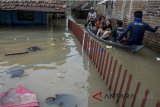 Warga menggunakan perahu untuk melintasi genangan banjir di Kampung Bojongasih, Dayeuhkolot, Kabupaten Bandung, Jawa Barat, Senin (26/2). Banjir akibat luapan sungai citarum dan intensitas curah hujan yang tinggi tersebut telah merendam sedikitnya 9000 rumah dengan 24.000 jiwa terdampak banjir dari 8 kecamatan di Kabupaten Bandung. ANTARA JABAR/Novrian Arbi/agr/18