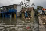 Sejumlah anak bermain dan berenang di genangan banjir yang tercemar di Kampung Bojongasih, Dayeuhkolot, Kabupaten Bandung, Jawa Barat, Senin (26/2). Banjir akibat luapan sungai citarum dan intensitas curah hujan yang tinggi tersebut telah merendam sedikitnya 9000 rumah dengan 24.000 jiwa terdampak banjir dari 8 kecamatan di Kabupaten Bandung. ANTARA JABAR/Novrian Arbi/agr/18