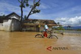 Warga menerobos genangan air banjir di Desa Tanjungsari, Kabupaten Tasikmalaya, Jawa Barat, Jumat (23/2). Banjir setinggi 50 cm sampai satu meter yang terjadi tadi malam akibat meluapnya sungai Cikidang ditambah intensitas curah hujan yang tinggi. ANTARA JABAR/Adeng Bustomi/agr/18 