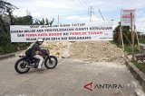 Pengendara motor memaksakan melewati jalan Jalan Regional Ring Road (R3) yang di blokir oleh warga di Kota Bogor, Jawa Barat, Senin (19/2). Pemblokiran jalan R3 oleh warga yang menjadi pemecah kemacetan di Kota Bogor tersebut dikarenakan Pemkot Bogor belum juga memberikan lahan pengganti atau ruislag, sehingga membuat kendaraan tidak dapat melintas. ANTARA JABAR/Yulius Satria Wijaya/agr/18.