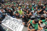 Ratusan Bonek duduk menutup jalan saat memberikan dukungan moral terhadap rekannya Jhonerly Simanjuntak yang menjalani sidang, di depan Pengadilan Negeri Surabaya, Jawa Timur, Kamis (22/2). Sekitar 750 personel baik dari kepolisian maupun TNI disiagakan untuk mengamankan jalannya sidang yang juga didatangi ratusan massa pendukung baik dari Bonek dan Persaudaraan Setia Hati Terate (PSHT) itu. Antara Jatim/Didik Suhartono/zk/18