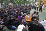 Polisi memberikan penjelasan agar tertib kepada ratusan anggota Persaudaraan Setia Hati Terate (PSHT) yang memantau jalannya sidang dengan terdakwa Jhonerly Simanjuntak, di Pengadilan Negeri Surabaya, Jawa Timur, Kamis (22/2). Sekitar 750 personel baik dari kepolisian maupun TNI disiagakan untuk mengamankan jalannya sidang yang juga didatangi ratusan massa pendukung baik dari Bonek dan PSHT itu. Antara Jatim/Didik Suhartono/zk/18