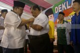 Bakal calon Bupati Margiono (kiri) menyematkan pin bergambar Margiono-Eko Prisidanto ke dada ketua tim relawan saat acara deklarasi 