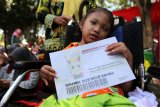 Anak penyandang disabilitas menunjukan kartu gandrung yang dapat digunakan secara gratis untuk fasilitas pelayanan publik dan  akses masuk wisata di banyuwangi   pada Festival Anak Berkebutuhan Khusus di Banyuwangi, Jawa Timur, Selasa (27/2). Festival yang melibatkan 2.000 anak berkebutuhan khusus dari sekolah tingkat TK hingga SLTA itu, bertujuan untuk memberikan motivasi guna mengembangkan minat dan bakatnya. Antara Jatim/Budi Candra Setya/zk/18.