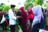 Bupati Tanah Laut H. Bambang Alamsyah menyerahkan bantuan bantuan beras sejahtera (Rastra) dari Program Keluarga Harapan (PKH), di Desa Tabonio, Kecamatan Takisung, Senin (5/2). Foto:Antaranews Kalsel/Arianto/G.