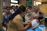 Pelajar mendapatkan suntikan vaksin saat dilakukan imunisasi massal difteri di SMAN 3 Kota Madiun, Jawa Timur, Senin (12/2). Imunisasi tersebut dimaksudkan untuk memberikan kekebalan tubuh guna mencegah penularan penyakit difteri. Antara Jatim/Foto/Siswowidodo/Zk/18