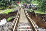 Warga menyaksikan proses evakuasi korban longsor di dekat rel KRD Bogor-Sukabumi sepanjang 40 meter yang menggantung akibat pondasi longsor di Desa Warung Menteng, Kecamatan Cijeruk, Kabupaten Bogor, Jawa Barat, Selasa (6/2). Perjalanan sejumlah kereta api, baik kereta api barang maupun kereta penumpang, lintas Bogor-Sukabumi mengalami gangguan akibat longsor yang terjadi pada Senin (5/2) karena tingginya curah hujan di wilayah Bogor. ANTARA JABAR/Arif Firmansyah