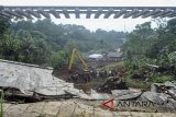 Petugas gabungan melakukan proses evakuasi korban longsor di dekat rel KRD Bogor - Sukabumi sepanjang 40 meter yang menggantung akibat pondasi longsor di Desa Warung Menteng, Kecamatan Cijeruk, Kabupaten Bogor, Jawa Barat, Selasa (6/2). Perjalanan sejumlah kereta api, baik kereta api barang maupun kereta penumpang, lintas Bogor-Sukabumi mengalami gangguan akibat longsor yang terjadi pada Senin (5/2) karena tingginya curah hujan di wilayah Bogor. ANTARA JABAR/Arif Firmansyah