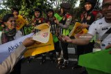 Sejumlah aktifis lingkungan dan warga yang tergabung dalam Indonesia Smile Club (ISC) membagikan tas kain kepada warga dan polisi saat Car Free Day di Jalan Darmo, Surabaya, Jawa Timur, Minggu (25/2). Kegiatan itu bertujuan untuk memberikan pemahaman kepada masyarakat tentang bahaya sampah plastik terhadap lingkungan hidup serta mengajak masyarakat untuk menghindari penggunaan tas plastik (kresek). Antara Jatim/Didik Suhartono/zk/18