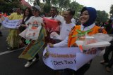 Sejumlah aktifis lingkungan dan warga yang tergabung dalam Indonesia Smile Club (ISC) membagikan tas kain kepada warga dan polisi saat Car Free Day di Jalan Darmo, Surabaya, Jawa Timur, Minggu (25/2). Kegiatan itu bertujuan untuk memberikan pemahaman kepada masyarakat tentang bahaya sampah plastik terhadap lingkungan hidup serta mengajak masyarakat untuk menghindari penggunaan tas plastik (kresek). Antara Jatim/Didik Suhartono/zk/18