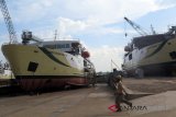 Seorang pekerja melintasi dua kapal perintis Tol Laut Sabuk Nusantara yang sedang dibangun di galangan kapal PT Stadefast Marine, Pontianak, Kalimantan Barat (23/2). Sebanyak tujuh buah kapal perintis tol laut Sabuk Nusantara yang dikerjakan di galangan tersebut, ditargetkan akan selesai pada pertengahan 2018. ANTARA FOTO/Sheravim/jhw/18
