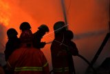 Petugas pemadam kebakaran memadamkan api yang membakar toko konveksi di Kawasan Pasar Baru, Jakarta, Selasa (27/2). Puluhan mobil pemadam kebakaran dikerahkan untuk memadamkan api yang membakar toko konveksi tersebut