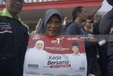 Warga memegang kalender berisi gambar sosialisasi pasangan calon Gubernur Jawa Timur Khofifah Indar Parawansa dan Emil Elestianto Dardak saat mengikuti kampanye tatap muka Cagub Khofifah di Pasar Ngemplak, Tulungagung, Jawa Timur, Minggu (25/2). Selain kampanye langsung, Khofifah memanfaatkan media poster, kalender dan stiker untuk mensosialisasikan pencalonannya di Pilkada Jatim, bepasangan Emil Elestianto Dardak. Antara jatim/Destyan Sujarwoko/zk/18