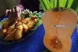 Seorang peserta menata nuget berbahan baku labu madu di sentral penghasil labu madu Desa Paron, Kediri, Jawa Timur, Selasa (20/2). Lomba memasak berbahan baku labu madu yang diikuti oleh sejumlah anggoa Kelompok Wanita Tani (KWT) tersebut guna mendorong kreatifitas menciptakan makanan pengganti atau pendamping nasi guna meningkatkan nilai ekonomis labu madu sekaligus mengurangi ketegantungan mengkonsumsi nasi sebagai makanan pokok. Antara Jatim/Prasetia Fauzani/zk/18