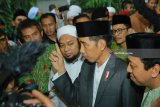 Presiden Joko Widodo memberikan keterangan kepada media ditemani  pengasuh Pondok KHR Achmad Azaim Ibrahimy (kiri) dan Ktua Partai PersatuanPembangunan Romahurmuziy (kanan) saat menghadiri Haul Majemuk Masyayikh di Pondok Pesantren Salafiyah Safi'iyah Sukorejo, Banyu Putih, Situbondo, Jawa Timur, Sabtu (3/2). Dalam Kunjungannya ke Pondok pesantren tersebut, Presiden berziarah ke makam Pahlawan Nasional KH Raden Sa'ad Samsul Arifin dan dilanjutkan menandatangani prasasti peresmian Universitas Ibrahimy. Antara jatim/Budi Candra Setya/zk/18.