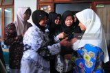 Istri mendiang Ahmad Budi Cahyanto guru SMAN 1 Torjun yang tewas dianiaya siswanya sendiri, Sianit Sinta (kanan) mendapatkan ucapan belasungkawa dari perwakilan PGRI Pamekasan di Desa Tanggumung, Sampang, Jawa Timur, Sabtu (3/2). Ahmad Budi Cahyanto tewas usai dianiaya siswanya sendiri MH saat pelajaran berlangsung, Jumat (1/2). Antara Jatim/Saiful Bahri/18