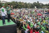 Pasangan calon Gubernur Jawa Barat Ridwan Kamil (kanan) dan calon Wakil Gubernur Jawa Barat Uu Ruzhanul Ulum (kiri) menyapa simpatisan dan warga saat acara Jalan Sehat 2018 Bandung Hejo Rindu Bandung Anu Hebring di lapangan Tegalega, Bandung, Jawa Barat, Minggu (11/2). Acara yang dimeriahkan dengan bazar sembako, pembagian paket umroh dan lain lain tersebut sekaligus menjadi perayaan ulang tahun yang ke-45 PPP di Jawa Barat serta perkenalan sejumlah calon Kepala Daerah yang diusung PPP di Jawa Barat. ANTARA JABAR/Novrian Arbi