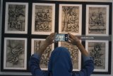 Pengunjung melihat lukisan berjudul Relief karya pelukis Sudibyo dalam pameran Lukisan bertajuk 