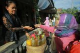 Pedagang melayani pembeli di pasar jajanan tradisional di Desa Wisiata Kemiren, Banyuwangi, Jawa Timur, Minggu (4/2). Pasar yang menjual makanan tradisional suku Osing yang diadakan setiap hari minggu itu, pembeli harus menggunakan kepeng atau kepingan uang kuno untuk bertransaksi. Antara jatim/Budi Candra Setya/zk/18.