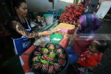 Pedagang melayani pembeli di pasar jajanan tradisional di Desa Wisiata Kemiren, Banyuwangi, Jawa Timur, Minggu (4/2). Pasar yang menjual makanan tradisional suku Osing yang diadakan setiap hari minggu itu, pembeli harus menggunakan kepeng atau kepingan uang kuno untuk bertransaksi. Antara jatim/Budi Candra Setya/zk/18.