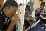Siswa tuna netra mengikuti kegiatan pelatihan melukis di Yayasan PSBN Wyata Guna, Bandung, Jawa Barat, Jumat (9/2). Kegiatan tersebut bertujuan untuk melatih dan mengedukasi para penyandang disabilitas khususnya tunanetra low vision ataupun buta untuk mampu berkarya dalam bentuk visual yang digagas oleh OSBN wyta Guna dan Komunitas Teman Tanpa Batas. ANTARA JABAR/Novrian Arbi