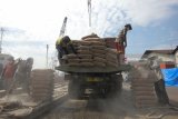 Pekerja mengangkut sak semen dari truk ke kapal di Pelabuhan Rakyat Kalimas Surabaya, Jawa Timur, Rabu (21/2). PT Semen Indonesia Tbk (SMGR) mencatat volume penjualan semen sebesar 28,96 juta ton sepanjang tahun 2017, meningkat 10,2% year on year (yoy) yakni pada 2016 SMGR mencatat penjualannya sebanyak 26,28 juta ton. Antara Jatim/Didik Suhartono/zk/18