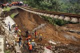 Pekerja melakukan perbaikan kontruksi jalur rel kereta yang terkena longsor di seputaran Stasiun Maseng, Kabupaten Bogor, Jawa Barat, Kamis (8/2). PT. Kereta Api Indonesia (KAI) Persero menargetkan pembangunan jembatan darurat dapat selesai pada (14/2) mendatang dan juga berupaya perbaikan bisa cepat selesai sehingga jalur dari Bogor menuju Sukabumi bisa segera diaktifkan kembali. ANTARA JABAR/Yulius Satria Wijaya