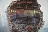 Pelajar menghabiskan waktu istirahat di kelas yang rusak di Sekolah Menengah Pertama (SMP) Negeri 1 Cikoneng, Desa Cikoneng, Kabupaten Bandung, Selasa (20/2). Kelas yang mengalami kerusakan pasca gempa Tasik dengan kekuatan 6,9 skala Richter pada Desember 2017 lalu hingga saat ini belum ada perbaikan yang menyebabkan terganggunya kegiatan belajar mengajar. ANTARA JABAR/Raisan Al Farisi/agr/18