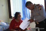 Tenaga Kerja Wanita (TKW) asal Tambaksari Surabaya, Ida Susilawati (kiri) berbincang dengan petugas kepolisian di Puskesmas Entikong, Kabupaten Sanggau, Kalbar, Kamis (8/2). Ida Susilawati (54) yang terserang stroke saat hendak berangkat ke Brunei Darussalam tersebut, telah dirawat di Puskesmas Entikong sejak Kamis (21/12/17) dan hingga kini belum dijemput oleh keluarganya karena keterbatasan biaya. ANTARA FOTO/Agus Alfian/jhw/18