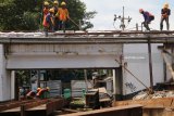 Pekerja menyiapkan pemasangan besi tiang penyangga pada jembatan kereta api guna dibangun rel jalur ganda (double track) di Kertosono, Nganjuk, Jawa Timur, Rabu (7/2). Pemerintah menargetkan double track lintas selatan Jawa selesai pada tahun 2019. Antara jatim/Prasetia Fauzani/zk/18