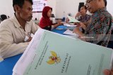 Warga mengambil sertifikat tanah program Pendaftaran Tanah Sistematis Lengkap (PTSL) di Kantor Kelurahan Burengan, Kota Kediri, Jawa Timur, Kamis (8/2). Penyerahan sertifikat tanah secara massal tersebut guna mendukung pencapaian target pemerintah tujuh juta sertifikat bidang tanah pada tahun 2018 melalui program PTSL dengan 1.570.000 sertifikat di antaranya berlokasi di Jawa Timur. Antara Jatim/Prasetia Fauzani/zk/18