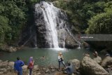 Pengunjung menikmati pemandangan air terjun Urang Kambu di Trenggalek, Jawa Timur, Minggu (11/2). Air terjun yang berada di dalam kawasan objek wisata Banyu Nget itu merupakan destinasi baru yang diminati wisatawan lokal maupun luar daerah karena airnya yang bersih dan bisa buat berenang. Antara Jatim/Destyan Sujarwoko/zk/18